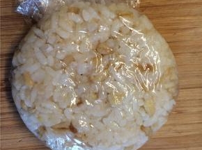 球形饭团放在案板上压扁后去除保鲜膜