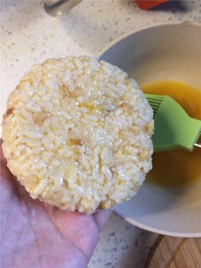 在压好的饭团一面刷上蛋液，有蛋液的一面朝下放入刷油烧热的平底锅中。