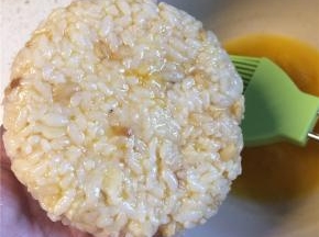 在压好的饭团一面刷上蛋液，有蛋液的一面朝下放入刷油烧热的平底锅中。