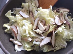 下入白菜片和香菇翻炒两分钟，加入老抽上色，翻炒均匀