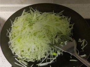 炒锅倒入少量油，烧热后加葱蒜炒香，加入萝卜丝进行翻炒