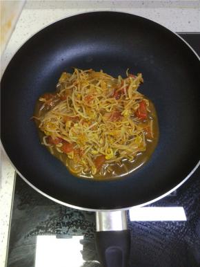 锅内放少许油加入西红柿炒至软烂，放入豆芽炒软