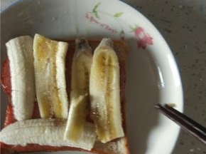 一片面包上面铺一层火腿，一层香蕉再一层火腿