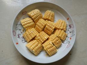 将洗好的玉米切成两指宽的粗段，再对开切开，装盘待用