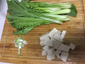 将豆腐和小青菜洗净，把豆腐用刀切成小块，小青菜切成两段，将大葱切碎备用