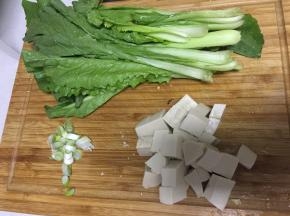 将豆腐和小青菜洗净，把豆腐用刀切成小块，小青菜切成两段，将大葱切碎备用