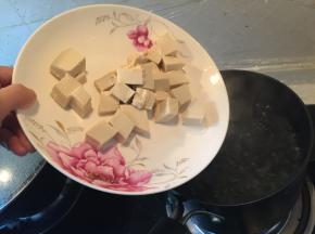 在锅里烧开水，把豆腐加入沸水中，加点盐