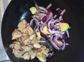 把鸡腿拨到锅边上，翻炒洋葱和姜片
