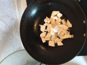 在锅里加入油，把豆腐块放进去炒一下