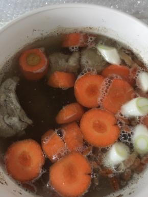 在锅内加入胡萝卜、白萝卜块、枸杞、大葱，加入2勺盐，继续烧30分钟