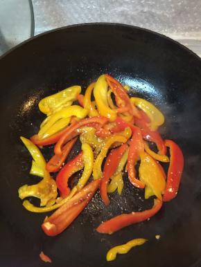 在锅里加入油，把彩椒倒进翻炒，加入盐和白芝麻