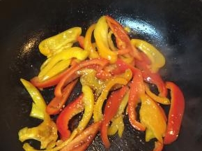 在锅里加入油，把彩椒倒进翻炒，加入盐和白芝麻