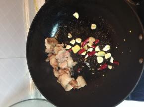 五花肉煸炒至白色后加入姜蒜和干辣椒，