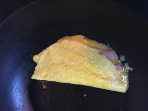 将另一半的蛋翻过来，如果怕烫，可以关火再卷