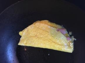 将另一半的蛋翻过来，如果怕烫，可以关火再卷