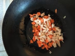 在热锅里加入油，可以加入少许盐，把胡萝卜丁和藕丁煸炒一下