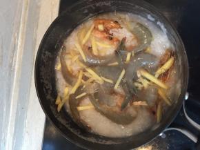 煮一会儿后将虾身放进锅里，翻至大米中，煮个6分钟