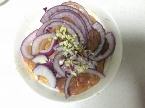 将鸡腿肉里加入料酒、生抽、蚝油，黑胡椒、糖和盐少许腌制半小时，在上面铺上洋葱、姜蒜沫儿