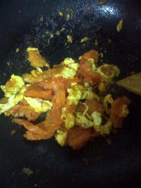 翻炒几分钟，待西红柿软后倒入已炒好的鸡蛋混在一起再炒一分钟，加入适量盐和糖。