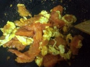 翻炒几分钟，待西红柿软后倒入已炒好的鸡蛋混在一起再炒一分钟，加入适量盐和糖。