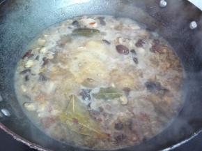 大火煮开后，放入香菇丁，（如想做卤蛋，此时可将煮熟的鸡蛋薄皮后放入锅中一起炖），转小火炖煮1个半小时。此时可以去下米煮饭了。另起一锅烫青菜或炒好青菜备用。