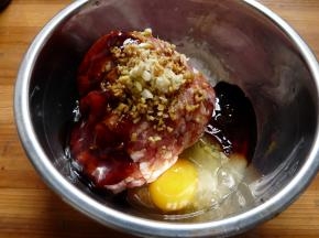 切好葱花、姜蒜末，将猪肉碎和葱姜蒜、鸡蛋、调料（料酒1汤勺、生抽2汤勺、老抽1汤勺、蚝油1汤勺、糖1汤勺、淀粉1汤勺、半茶勺盐）和适量胡椒粉一起搅拌均匀。注意必须往同一个方向搅拌，直至发胶。