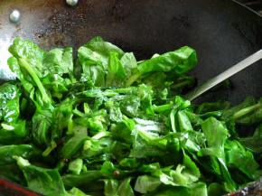 下豌豆尖翻炒几下稍微软塌后，撒2小勺盐、2小勺味精，翻炒均匀。