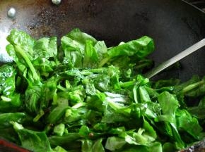 下豌豆尖翻炒几下稍微软塌后，撒2小勺盐、2小勺味精，翻炒均匀。