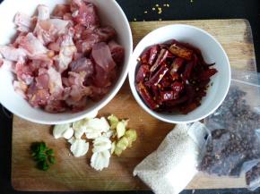 处理食材。鸡肉剁成约3厘米的小块，放少许料酒、适量盐拌匀腌制20分钟。鸡肉炸后基本很难再入味了，因此盐要放够，盐的多少直接决定了最后肉内的咸度（不太确定放多少盐的先在表面撒薄薄一层，然后拌开在新一面再撒一层，如此反复确保所有鸡肉沾盐即可）。蒜拍碎，姜切小块，葱切葱花，辣椒剪小段。