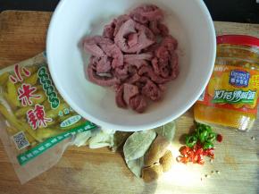 食材备齐。牛肉切丝，加生抽（一汤勺左右即可，因为黄灯笼辣椒酱也有盐分）、少许糖、胡椒粉、生粉（洒薄薄一层在肉面上即可，洒太多肉过嫩会丧失肉本身的质感），拌匀腌半小时。蒜拍好，尖椒指天椒切圈备用。