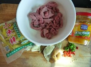 食材备齐。牛肉切丝，加生抽（一汤勺左右即可，因为黄灯笼辣椒酱也有盐分）、少许糖、胡椒粉、生粉（洒薄薄一层在肉面上即可，洒太多肉过嫩会丧失肉本身的质感），拌匀腌半小时。蒜拍好，尖椒指天椒切圈备用。