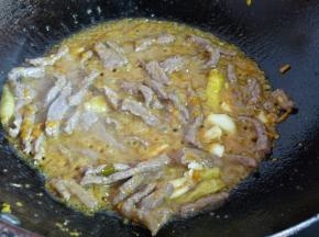 牛肉丝加入少许油拌一下以便下锅容易划散。锅内小火热油，将蒜、黄灯笼辣椒酱放入，炒香后加入泡椒及少许泡椒汁，转旺火下牛肉翻炒，肉变色后再稍作翻炒即可出锅。