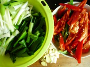 处理配菜。青红椒斜刀切片，蒜苗切成6cm左右长段（根部和茎斜切），如喜欢姜蒜可切少许姜蒜。