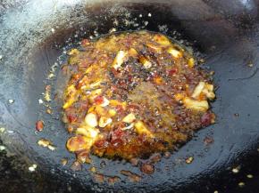 将刚才捞出的油放入锅内，小火热油，随后放入姜蒜爆香，再放入2勺豆瓣酱炒出红油，然后放入一把花椒爆香（花椒越多越香，不喜欢吃花椒的可以在放姜蒜前先放花椒爆香后把花椒捞出），再放入1勺豆豉炒匀。