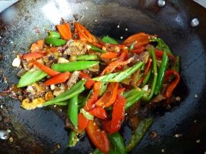 将肉片倒入翻炒几下，随后倒入青红椒一起翻炒均匀。