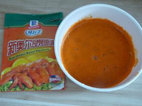 将适量奥尔良调料粉和清水混合均匀（清水以刚好能没过鸡翅的量为准，不用太多也不要太少）。每个牌子的调料粉口味会略微不一样，有的偏甜有的偏辣，可自行选择；包装上都会写有多少克肉需要多少克粉，可以根据包装上的指导进行调整。