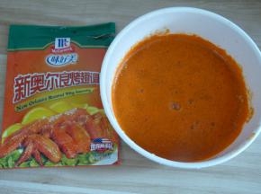 将适量奥尔良调料粉和清水混合均匀（清水以刚好能没过鸡翅的量为准，不用太多也不要太少）。每个牌子的调料粉口味会略微不一样，有的偏甜有的偏辣，可自行选择；包装上都会写有多少克肉需要多少克粉，可以根据包装上的指导进行调整。