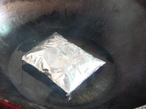 炒锅中放些许油，小火烧至冒烟（筷子插进去会立即冒出许多小气泡时），将鸡翅包放入烤。2分半钟后翻面继续再烤2分半钟（翻面时要快，否则容易油爆伤到）。过程中锡纸有膨胀是正常现象。