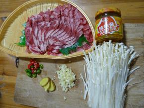 准备好食材：肥牛提前解冻洗净，蒜切碎，姜切片，青红尖椒切圈，金针菇剪去根部洗干净。