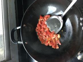 锅内再倒少许油，把番茄倒入锅内翻炒，加适量盐、糖、水在锅中