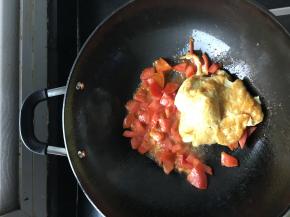 当番茄出汁后，把之前炒好的鸡蛋倒入锅内，把鸡蛋跟番茄翻炒均匀，