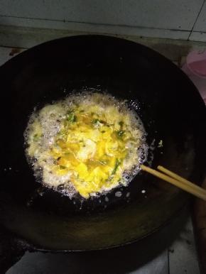 在锅内倒入适量的花生油，打散鸡蛋后，倒入油中，用筷子不断搅动鸡蛋