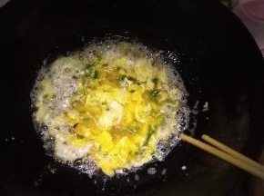 在锅内倒入适量的花生油，打散鸡蛋后，倒入油中，用筷子不断搅动鸡蛋