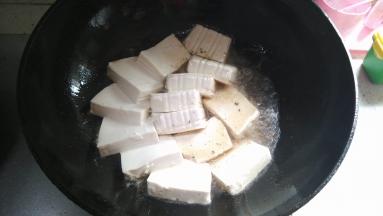 将盒装豆腐拆开切块后缓慢倒入油锅中