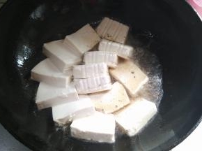 将盒装豆腐拆开切块后缓慢倒入油锅中