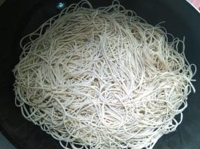 在锅内倒入适量的花生油，放入适量的面条