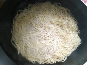 放入适量的面条，不断翻炒