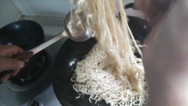 放入适量的面条，不断翻炒