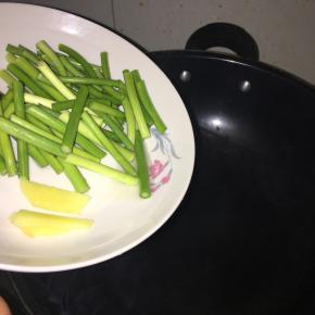 热锅倒油，先下生姜、蒜苗爆炒