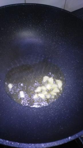 锅里倒入适量油加入大蒜爆香如图